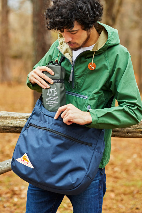 An image of a guy packing his Pokeboo Packable Boots in their Carry Case into another bag to store for travelling until he needs to swap back to his Pokeboo Boots again