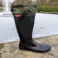 One Pokeboo TREAD Packable Boot standing upright next to a pond in a park.